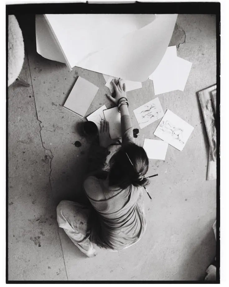 The designer seen from above, sketching on the studio floor